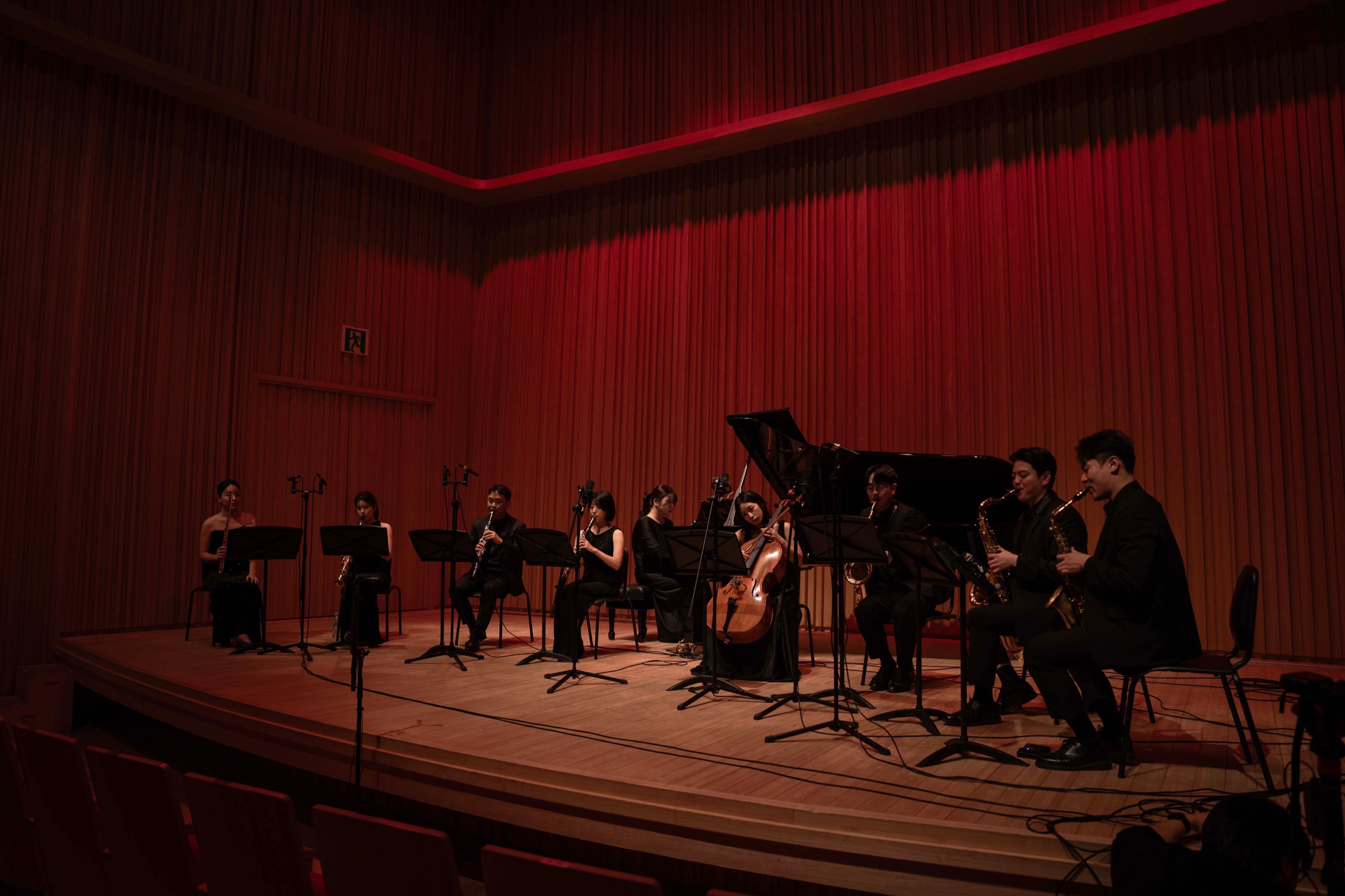 Meilleur Ensemble performing on stage in front of a red curtain